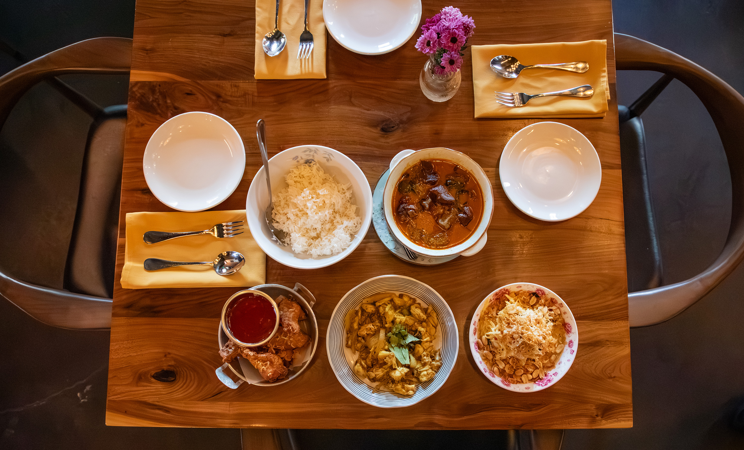A table with several Thai dishes.